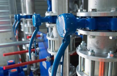 Blue actuated valves mounted on flanged pipework.